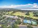 Aerial view showcases the community's pool, clubhouse, and tennis courts with lake views at 1473 Lakemist Ln, Clermont, FL 34711