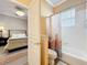 View into the bedroom and bathroom with tub and shower combo featuring a shower curtain at 1473 Lakemist Ln, Clermont, FL 34711