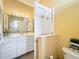 Full bathroom with a toilet and white vanity, featuring a large mirror at 1473 Lakemist Ln, Clermont, FL 34711
