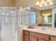 Bathroom featuring a glass-enclosed shower and a cherry vanity with a large mirror at 1473 Lakemist Ln, Clermont, FL 34711