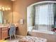 Bathroom featuring a soaking tub, decorative chair, and large window with curtains at 1473 Lakemist Ln, Clermont, FL 34711
