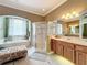 Luxurious bathroom featuring a glass-enclosed shower, soaking tub, and double vanity at 1473 Lakemist Ln, Clermont, FL 34711