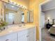 Bright bathroom with a white vanity, large mirror, and view into the adjacent bedroom at 1473 Lakemist Ln, Clermont, FL 34711