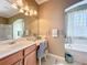 Bathroom vanity area with marble counters, bright lighting, sink and stylish chair with tub nearby at 1473 Lakemist Ln, Clermont, FL 34711
