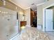 Spacious bathroom featuring a large shower with glass door, double sink vanity, and decorative ottoman at 1473 Lakemist Ln, Clermont, FL 34711