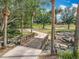 Charming wooden bridge crossing a stream with lush landscaping and palm trees in a serene setting at 1473 Lakemist Ln, Clermont, FL 34711