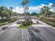 Inviting community entrance featuring palm trees, an American flag, and a well-maintained gatehouse at 1473 Lakemist Ln, Clermont, FL 34711