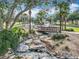 Scenic community stream with decorative rockwork, lush foliage, and a charming wooden bridge at 1473 Lakemist Ln, Clermont, FL 34711