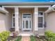 Detailed front porch with stone pillars, glass paned windows, and well-kept landscaping at 1473 Lakemist Ln, Clermont, FL 34711