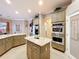 Spacious kitchen featuring granite countertops, an island, stainless steel appliances, and custom cabinets at 1473 Lakemist Ln, Clermont, FL 34711