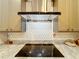 Kitchen cooktop features a stylish backsplash and a modern range hood at 1473 Lakemist Ln, Clermont, FL 34711