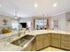 Bright kitchen showcasing a stainless steel sink, granite countertops, and views into the living and dining spaces at 1473 Lakemist Ln, Clermont, FL 34711