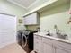 Laundry room with new front load washer and dryer plus sink and granite countertop at 1473 Lakemist Ln, Clermont, FL 34711