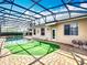 Enclosed pool, bordered by manicured lawn, is located next to the home's patio at 1473 Lakemist Ln, Clermont, FL 34711