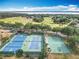 Aerial view of community tennis and basketball courts near lush landscaping and community roads at 1473 Lakemist Ln, Clermont, FL 34711