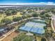 Overhead view of community tennis and basketball courts amid lush trees at 1473 Lakemist Ln, Clermont, FL 34711
