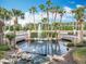Pond with a fountain and rock features surrounded by palm trees and manicured landscaping at 1473 Lakemist Ln, Clermont, FL 34711