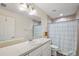 Bathroom with a large mirror, vanity, and tiled shower with a curtain at 15117 Se 94Th Ter, Summerfield, FL 34491