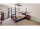 Primary bedroom featuring a beautiful four-poster bed frame and a window with natural light at 15117 Se 94Th Ter, Summerfield, FL 34491