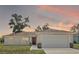 Charming single-story home with a well-maintained lawn and inviting curb appeal at sunset at 15117 Se 94Th Ter, Summerfield, FL 34491