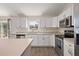 Bright kitchen features white cabinets, stainless steel appliances, and a view to the backyard at 15117 Se 94Th Ter, Summerfield, FL 34491