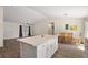 The open living room with a large kitchen island and adjacent dining area is filled with natural light at 15117 Se 94Th Ter, Summerfield, FL 34491