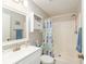 This clean bathroom is well-lit with a tub/shower combination and storage shelves at 1622 Navidad St, The Villages, FL 32162
