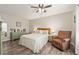 The serene primary bedroom is furnished with patterned bedding, a ceiling fan, and light-colored walls at 1622 Navidad St, The Villages, FL 32162