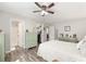 Spacious bedroom featuring a ceiling fan, walk-in closet, ensuite bath, and wood-look flooring at 1622 Navidad St, The Villages, FL 32162