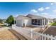 Inviting light home featuring a screened porch, an attached garage, and a charming white picket fence at 1622 Navidad St, The Villages, FL 32162