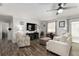 Cozy living room featuring luxury vinyl plank floors, a ceiling fan, and comfortable seating, plus backyard view at 1622 Navidad St, The Villages, FL 32162