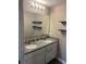 Bathroom featuring a double sink vanity with granite countertop and sleek floating shelves at 1721 Nebraska Loop, Sumterville, FL 33585