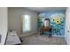 Cozy bedroom with a sunflower mural, neutral carpet and trim, and natural light at 1721 Nebraska Loop, Sumterville, FL 33585