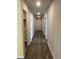 Hallway with wood floors, neutral walls, recessed lighting, and white doors at 1721 Nebraska Loop, Sumterville, FL 33585