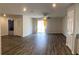 Open-concept living room with wood-look flooring and a sliding glass door leading to the patio at 1721 Nebraska Loop, Sumterville, FL 33585