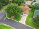 Aerial view of a lovely single story house, highlighting roof, front yard, driveway, and nearby trees at 17349 Se 76Th Flintlock Ter, The Villages, FL 32162