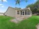 Exterior view of the home's rear including a small patio and the screened-in sunroom at 17349 Se 76Th Flintlock Ter, The Villages, FL 32162