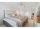 Comfortable bedroom features a ceiling fan, soft carpet, and a queen bed with floral bedspread at 17349 Se 76Th Flintlock Ter, The Villages, FL 32162