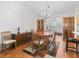 An open dining area features stylish chandelier, hardwood floors and seamlessly connects to the kitchen at 17349 Se 76Th Flintlock Ter, The Villages, FL 32162
