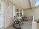View of the front porch area with rocking chairs and a white picket fence at 17349 Se 76Th Flintlock Ter, The Villages, FL 32162