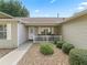 Inviting front porch with a white picket fence, gravel landscaping, and an entrance door at 17349 Se 76Th Flintlock Ter, The Villages, FL 32162