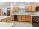 Kitchen with stainless steel dishwasher, sink, stove, and light wood cabinets at 17349 Se 76Th Flintlock Ter, The Villages, FL 32162