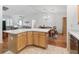 View of the kitchen island with dining area and living room beyond at 17349 Se 76Th Flintlock Ter, The Villages, FL 32162