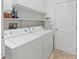 Laundry room featuring a washer, a dryer, and shelving space at 17349 Se 76Th Flintlock Ter, The Villages, FL 32162