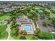 A clubhouse with a pool, surrounded by palm trees and lounge chairs with ample parking at 17349 Se 76Th Flintlock Ter, The Villages, FL 32162