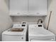 Convenient laundry area with modern, white appliances and overhead cabinets at 1795 Piedmont Pl, Lake Mary, FL 32746
