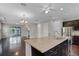 Open-concept living area with hardwood floors, leading to a kitchen island and an outdoor balcony at 1795 Piedmont Pl, Lake Mary, FL 32746