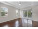 Serene bedroom with natural light, tray ceilings, access to a private balcony, and hardwood floors at 1795 Piedmont Pl, Lake Mary, FL 32746