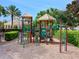 Community playground featuring colorful equipment, mature shade trees and professional landscaping at 1795 Piedmont Pl, Lake Mary, FL 32746