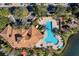 Aerial view of the pool area with lounge chairs, palm trees, and a nearby playground at 1795 Piedmont Pl, Lake Mary, FL 32746